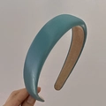 Close-up of a teal blue padded headband showing soft fabric texture and brown non-slip lining - Blue Gold