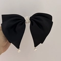 Detail of elegant black fabric bow clip featuring dense pearl clusters and hanging pearls - Black