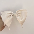Dettaglio fiocco in raso color crema con perle multistrato e perline pendenti eleganti - Albicocca