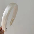 Close-up of beige satin padded headband showing smooth texture and thick cushioning - Creamy White