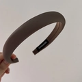 Detailed close-up showing the thick sponge padding and handmade label of this brown headband - Coffee