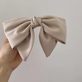 Close-up of large champagne satin bow hair clip with elegant silk texture and glossy finish - Khaki