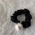 Detail view of a black scrunchie with a glossy white pearl on white crepe paper - 2.4cm Size Pearl