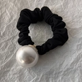 Detailed view of black ribbed scrunchie with a large white pearl and gold metal base - 3cm Size Pearl
