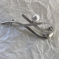 Dettaglio della molletta per capelli argentata con strass scintillanti e perla centrale - Argento