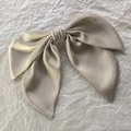 Detailed macro view of high-quality champagne satin fabric French bow hairclip with silk texture - Apricot