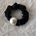 Detail view of a large faux pearl secured by gold metal claws on a black scrunchie hair tie - 2.5cm Pearl with Base