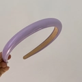 Detail eines lavendelfarbenen gepolsterten Stirnbands mit Glanzeffekt und Samtfutter - Lila