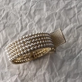 Dettaglio di bracciale dorato di lusso con sei file di perle e chiusura trapuntata - Perla