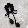 Détail d'un chouchou en satin noir avec un nœud élégant et des pendentifs tulipe - Noir