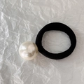 Dettaglio di un elastico nero ad alta elasticità con una grande perla sintetica color crema - Stile con Perla Grande Singola