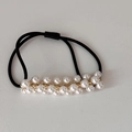 Dettaglio di elastico per capelli nero con doppia fila di perle bianche e maglie dorate - Design con Doppia Fila di Perle
