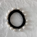 Dettaglio di elastico nero ad alta elasticità con perle bianche su carta stropicciata - Stile Avvolgente Con Piccole Perle Multiple