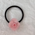 Dettaglio di un fiore di camelia in resina rosa su un elastico per capelli nero flessibile - Rosa