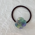 Dettaglio dell'elastico per capelli con camelia sfumata e cinturino nero elastico - Sfumato Blu Verde