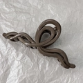 Dettaglio di un grande fermaglio per capelli marrone scuro perlato con design ondulato - Marrone Perlato