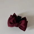 Detail of wine red layered satin bow hair clip with durable black plastic claw design - Burgundy