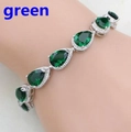 Detailed view of silver bracelet featuring pear-cut green gemstones with halo diamond setting - Green