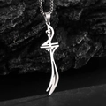 Macro shot of silver stainless steel Zulfiqar sword pendant on black stone surface - Steel