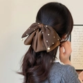 Elegante donkerbruine haarklem met strik, stippen en witte parels voor een klassieke look - Bruin