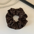Nahaufnahme eines kaffeebraunen Blumen-Scrunchie mit feinen Falten und Vintage-Muster - Doppelseitig Floral
