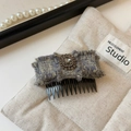 Dettaglio del fermaglio a fiocco in tweed con fiore di cristallo e pettine nero - Grigio Blu Pettine a Incastro