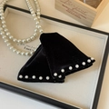 Dettaglio di fermagli per capelli in velluto nero con perle su un vassoio elegante - Stile in Velluto con Perle sul Bordo / Nero