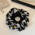 Detail of knitted scrunchie featuring black and white houndstooth pattern and gold metal tag - Black White Houndstooth / Black