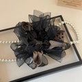 Detail eines eleganten Haargummis mit Leopardenmuster, Organza und Perlenverzierung - Kaffee Leopard