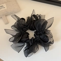Detail von schwarzem Organza-Haargummi mit glänzenden Strasssteinen und Netzstruktur - Schwarz