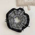 Dettaglio di un elastico per capelli vintage a quadretti con fiocco e perle eleganti - Houndstooth