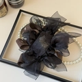 Dettaglio del fiocco multistrato in organza nera e tessuto marrone con nastro scritto - Marrone