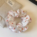 Detailed view of white chiffon scrunchie with sweet red cherry and blue bow patterns - White