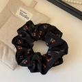 Detail of black cherry print scrunchie with soft fabric folds and vintage bow pattern - Black