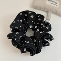 Primo piano di scrunchie floreale nero con motivo a cuori bianchi e trama in tessuto arricciato - Nero Con Fantasia Floreale Bianca