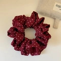 Dettaglio dell'elastico scrunchie bordeaux a pois con trama in tessuto setoso e pieghe - Rosso Piccoli Pois