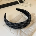 Detail van geblokte stoffen hoofdband op gewatteerde display met parelketting - Zwart en Grijs
