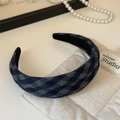 Detailopname van een blauw en grijs geblokte haarband met geweven textuur op gewatteerde stof - Marineblauw