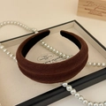 Detail showing thick brown sponge headband with textured fabric and soft warm lighting - Brown