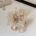 Dettaglio di uno scrunchie in pizzo e organza rosa tenue con perline delicate - Beige