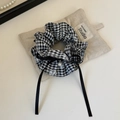 Dettaglio dello scrunchie a quadretti con fiocco nero e piccolo ciondolo di perla - Quadri Nero