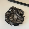 Detail of floral scrunchie with cream flowers on black fabric and layered ruffled edges - Black Four-Layer Floral