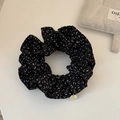 Detalle del coletero negro con estampados blancos y colgante de metal dorado - Leopardo Negro Etiqueta de Metal