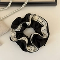 Detail van een zwarte satijnen scrunchie met witte kanten rand in Franse vintage stijl - Zwart