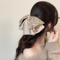 Détail de la pince à cheveux avec nœud en satin, rubans à carreaux et perles - Café Clair
