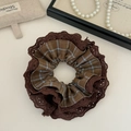 Detailopname van een vintage bruine bloemenstof scrunchie met fijne kanten randen - Donker Koffie
