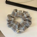 Dettaglio scrunchie a scacchi grigio-blu con fiocco bianco e pendente a fiore dorato - Fiocco a Quadri Con Pendaglio Fiore / Marrone