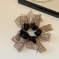 Dettaglio scrunchie in raso nero con fiocco a quadri marroni e catena di perle - Motivo Floreale Champagne