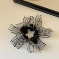Dettaglio di scrunchie in organza a scacchi con perle bianche e tessuto plissettato nero - Motivo Floreale Blu-Nero
