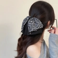 Fermaglio per capelli a fiocco floreale con doppio strato e perline su capelli neri ondulati - Stile Fiocco